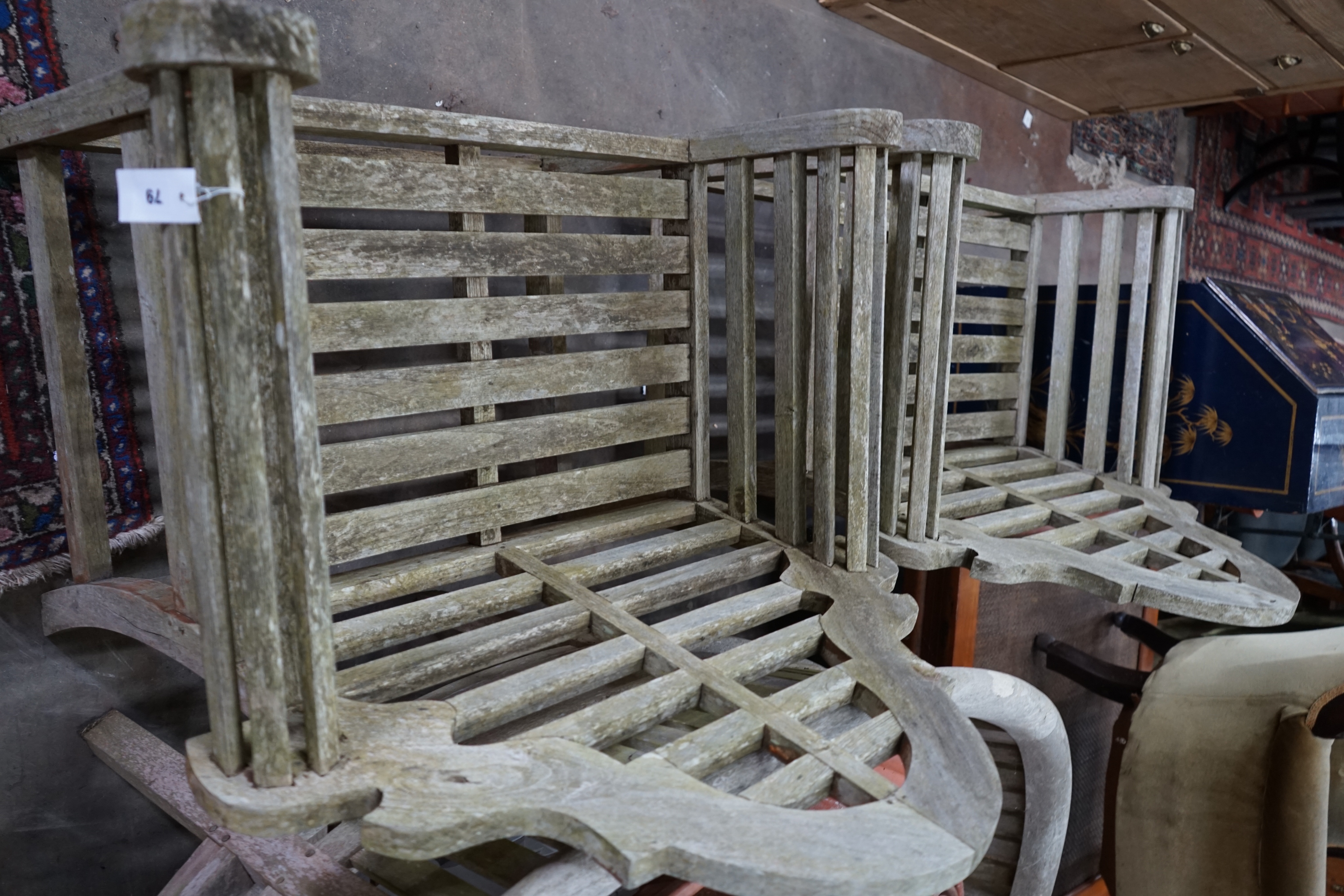 A pair of Lutyens style weathered teak garden armchairs, width 90cm depth 54cm height 105cm